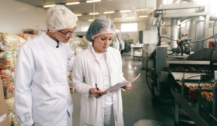 deux femmes en tenue de protection dans une entreprise du secteur alimentaire