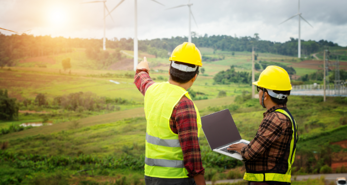 homes de dos en tenue de protection regardant des éoliennes